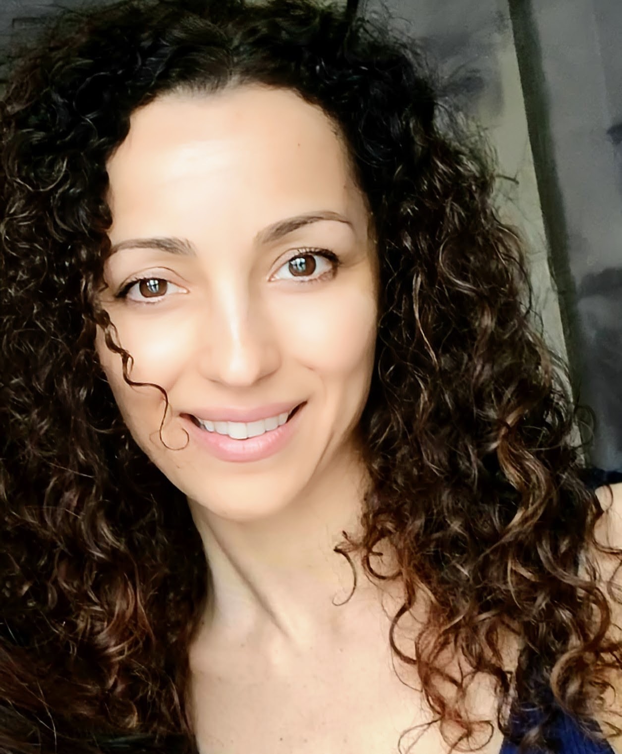 Sharon Caruso smiling with her natural curls